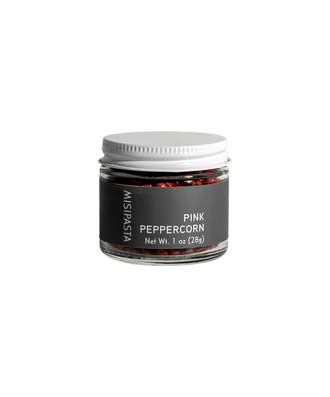 Jar of pink peppercorns with a black label on a white background